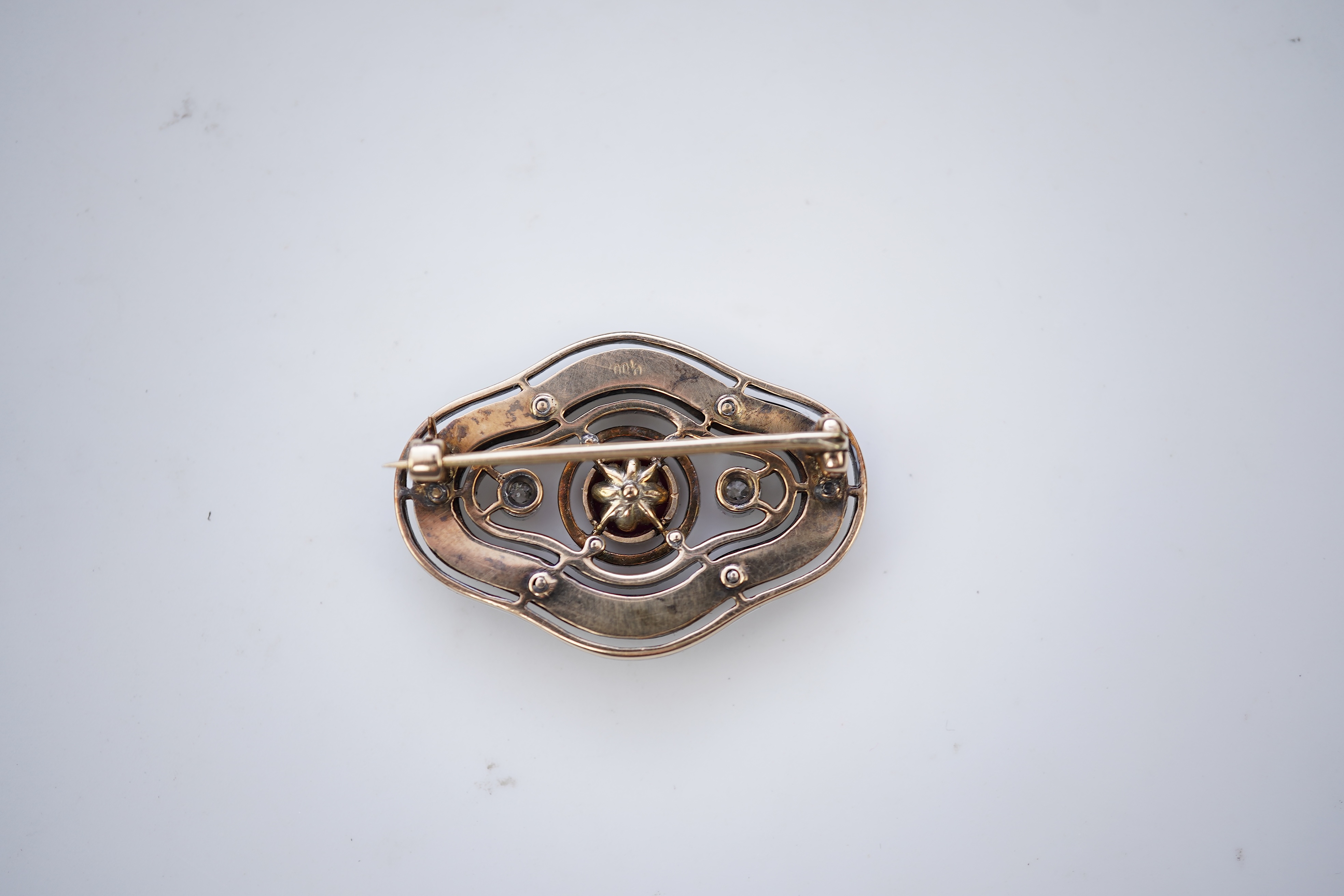 An unusual Art Deco onyx, enamel, ruby and diamond brooch, circa 1920